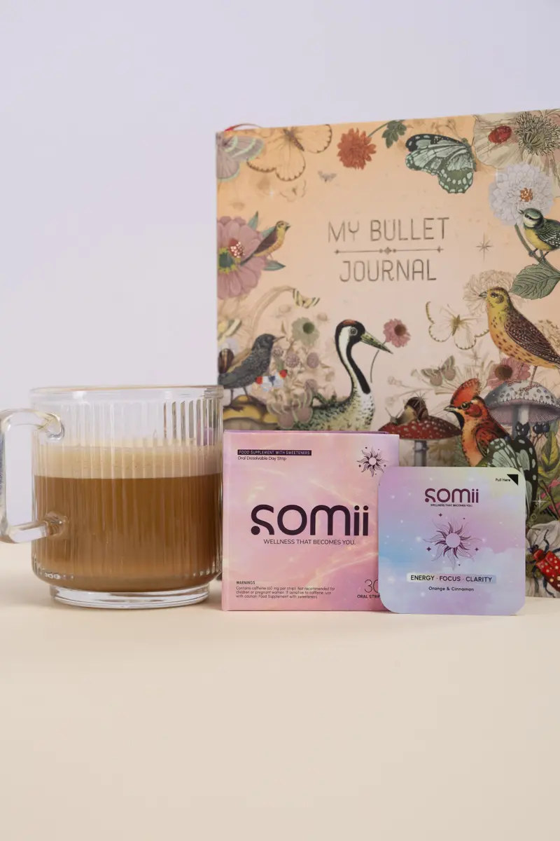 A Somii morning box and strip beside a coffee and an illustrated journal